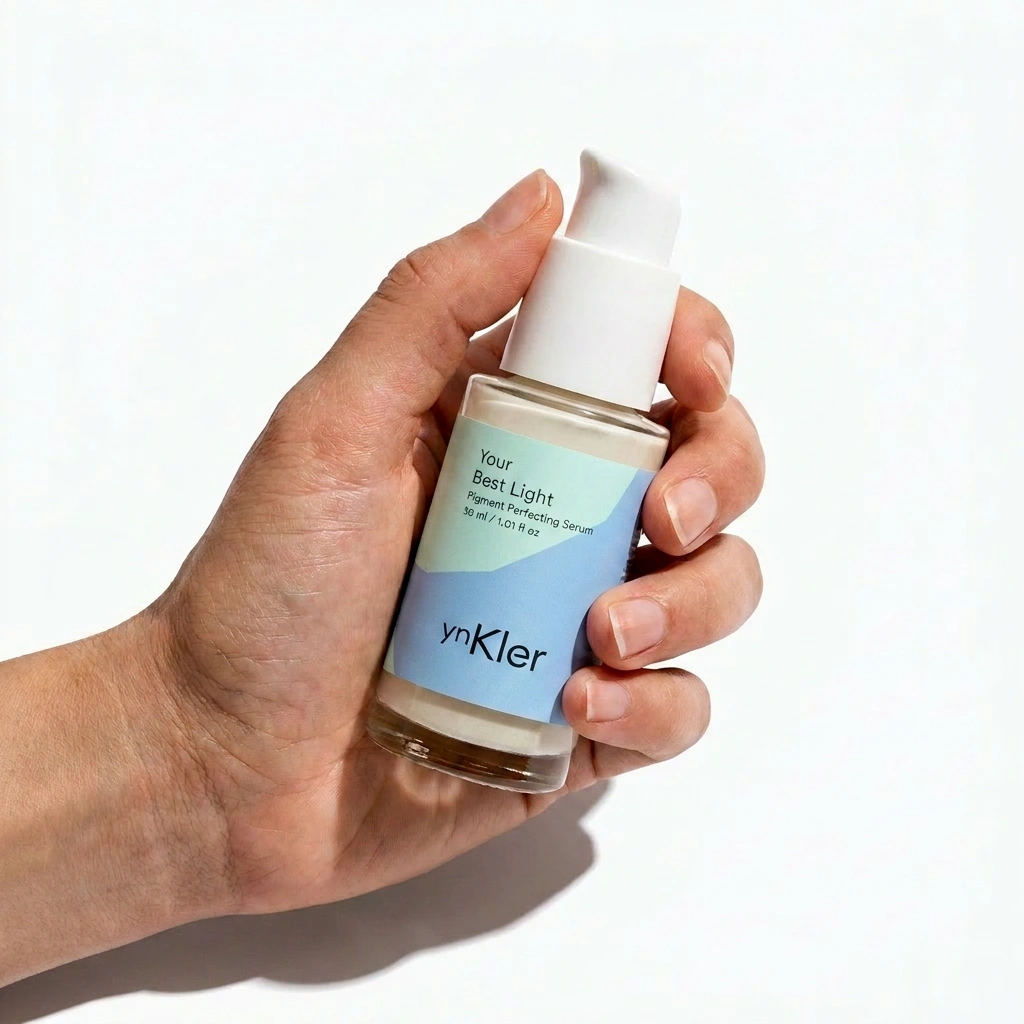 Hand holding a skincare serum bottle labeled 'ynKler' against a white background