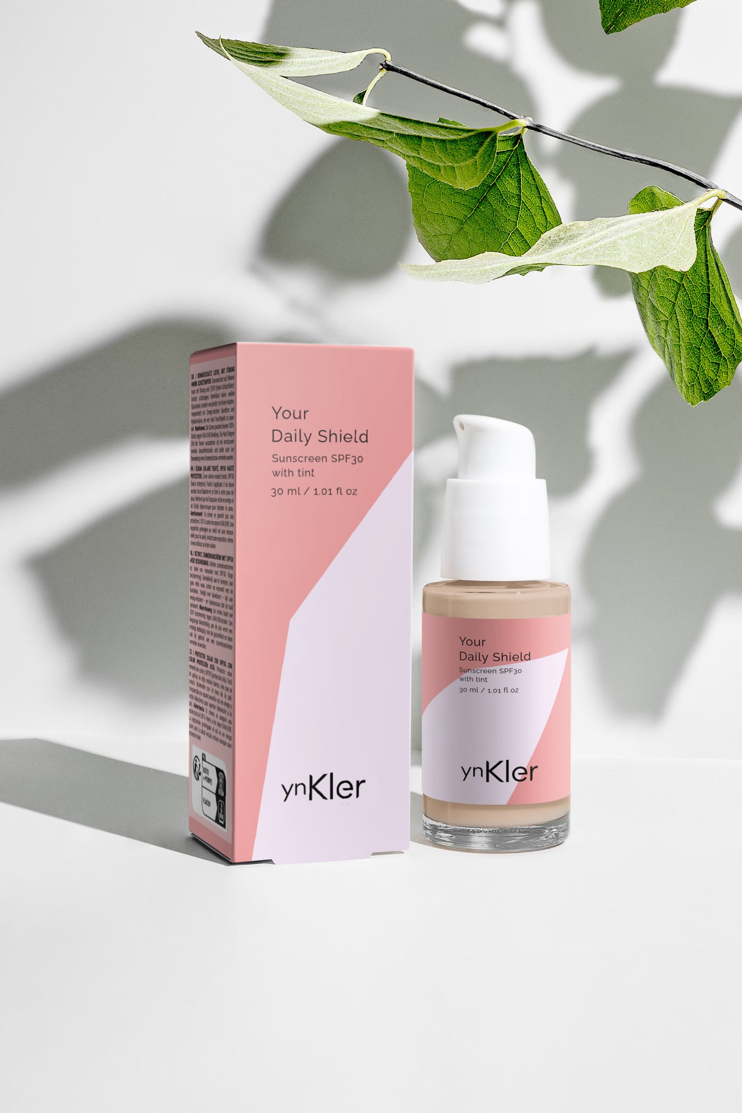 ynKler skincare bottle and packaging with a leafy branch on a light background